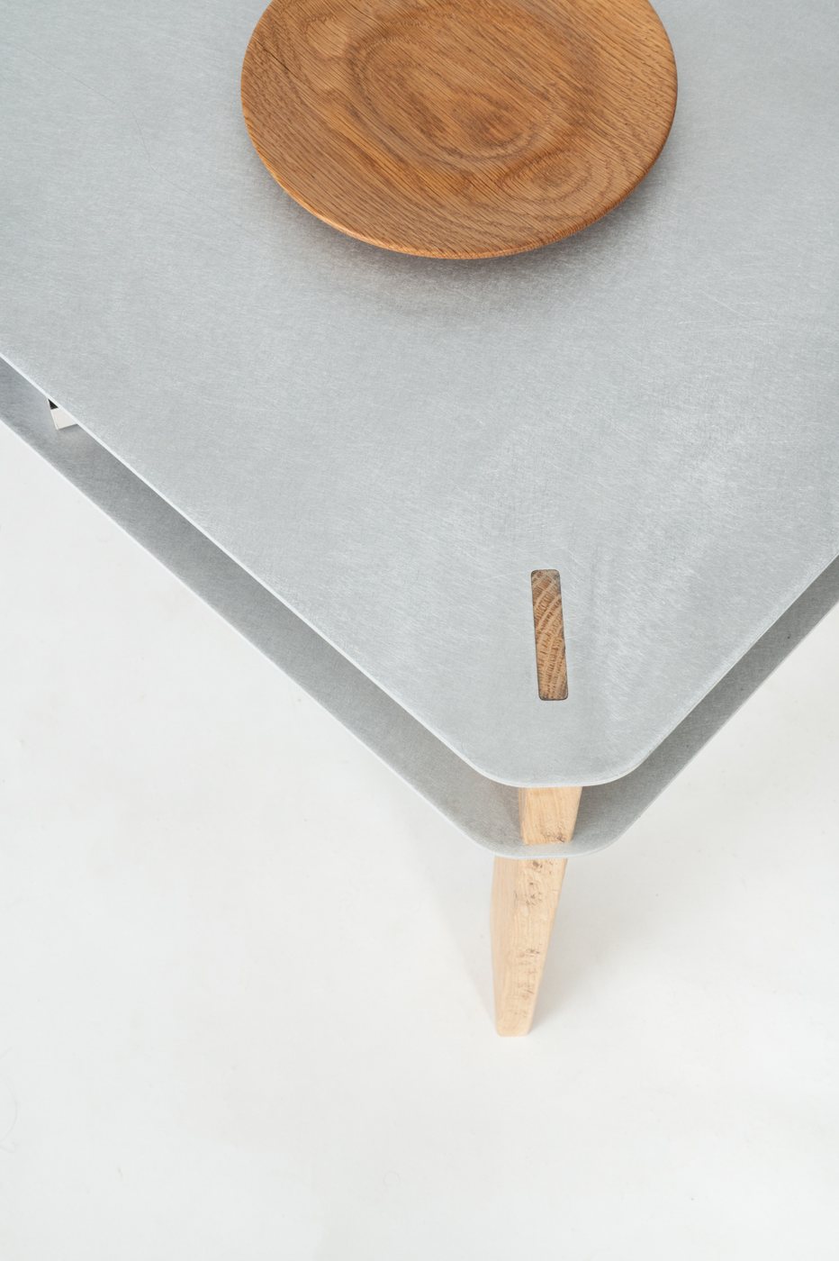 Close-up of the sanded aluminum surface and oak joinery tab